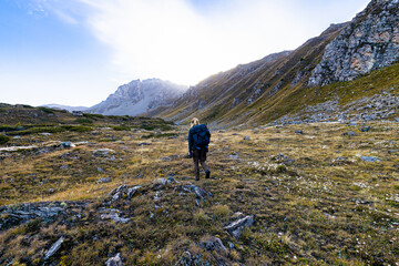 An alone huntress walking in the Alps mountains in a beautiful morning.