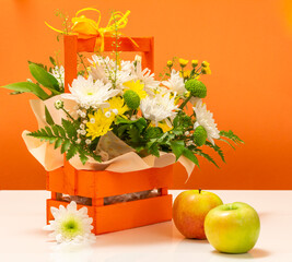 Beautiful bouquet of yellow and white flowers with wooden basket.