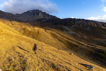 An alone hunter walking in the Alps mountains in a beautiful morning.