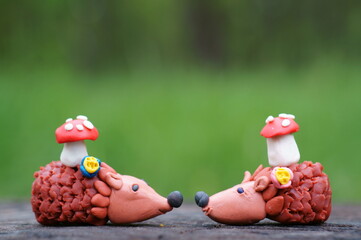 Two toy hedgehogs with mushrooms.