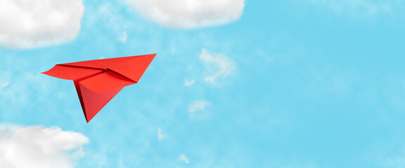 Red paper plane in the blue cloudy sky. The concept of rest, plans, and goals. copy space....
