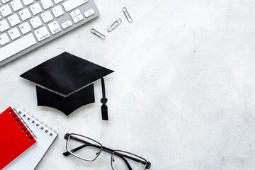 Graduation hat or academic cap on desk with students supplies