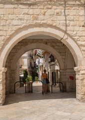 Girl hiding from the sun under arch in Bari Apulia