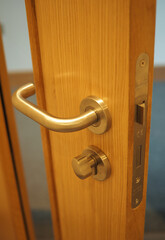 Obraz premium Chrome door handle with twist lock on wooden door