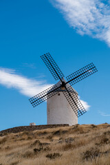 Fototapeta na wymiar Beautiful wind mill isolated in top of a hill near to Consuegra city in Castilla-La Mancha - Spain. Cloudy day.