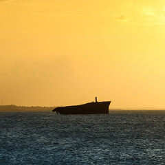 Sunset on the sea of Fortaleza with silhouette of a shipwreck