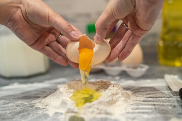 young girl in the kitchen breaks eggs and sprinkles flour to bake a cool birthday cake.