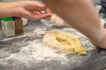 young girl in the kitchen breaks eggs and sprinkles flour to bake a cool birthday cake.
