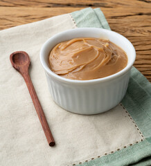 Doce de leite, traditional brazilian creamy milk sweet over wooden table
