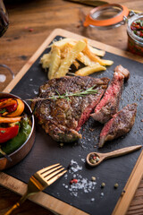 Delicious beef steak served with french fries with parmesan and rosemary