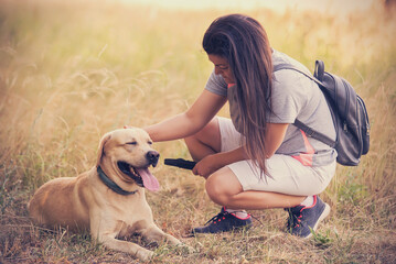 Brown hair woman with her labrador dog in the nature