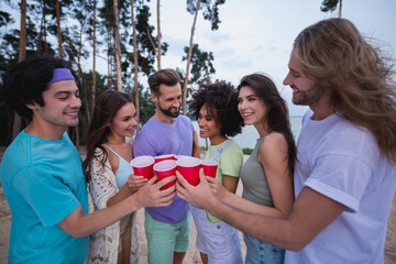 Photo of millennial guys ladies drink beer wear casual outfil outdoors on the beach