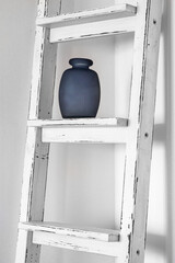 white ladder with a blue vase as a decoration in a modern interior