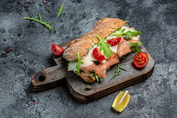 Sandwiches with homemade ciabatta bread, salted salmon fish, parmesan cheese, capers, cherry...