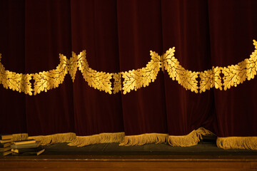 Theatrical dark red velvet curtain with golden fringe. Texture background for design.