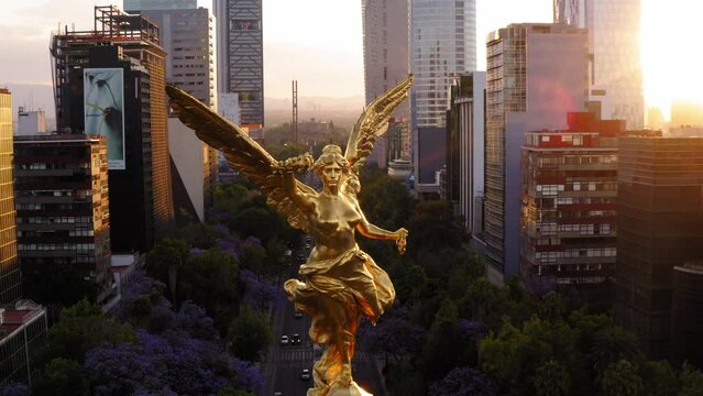 Aerial Shot Of The Angel Of Independence On Road In City, Drone Flying Backwards During Sunset - Mexico City, Mexico