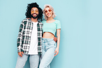 Smiling beautiful woman and her handsome boyfriend. Sexy cheerful multiracial family having tender moments on beige background in studio. Multiethnic models hugging. Embracing each other. Love concept