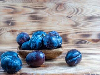 Fresh juicy plums. Plums on a wooden background.