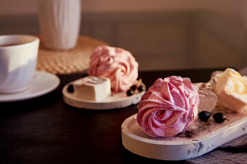 Natural homemade sugar and gluten free purple marshmallows with currant taste in low key and cup of tea. Autumn cozy atmosphere. Healthy sweets, natural food