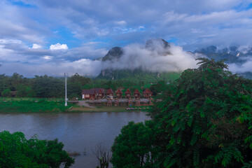 Fototapeta premium Vang Vieng Laos a beautiful city on the river with huge rising mountains and slow flowing river. 