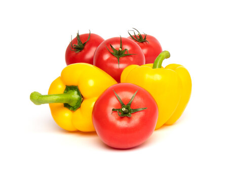 Fresh vegetables, whole red tomato and yellow bell pepper (paprika) isolated on white background