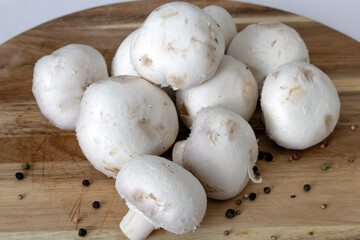 Fresh white champignons mushrooms on cutting board. Vegan concept.