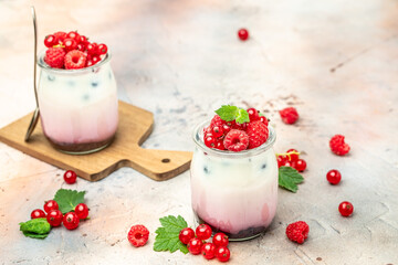 Raspberry dessert cheesecake, trifle, mouse in a glass. Raspberry Greek yogurt granola parfait on a light background. Restaurant menu, dieting, cookbook recipe