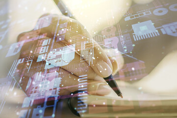 Multi exposure of abstract software development hologram and man hand writing in notebook on background, research and analytics concept