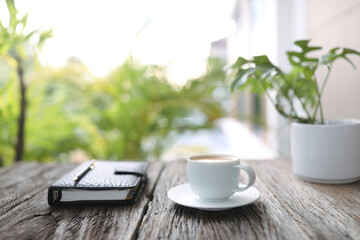 White coffee cup with tablet and notebook at outdoor