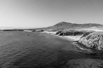 Playa de la Cera, Playa del Pozo and Playa Mujeres are popular and beautiful beaches in Lanzarote, Canary Islands, Spain. Black and white.
