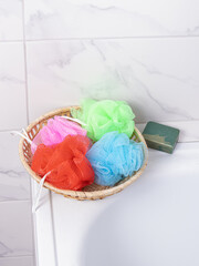 Set of nylon washcloths for the shower in basket on bathroom background