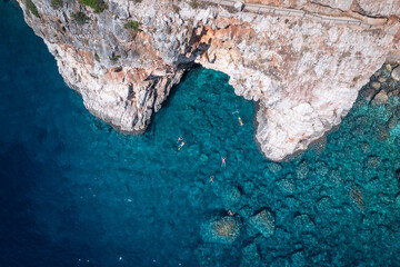 Rocky pit at Pasjača beach. Tourists swimming to admire the beauty of nature.