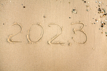 Top view of a 2023 text written on the beach sand, mockup. New Year party, seaside view, banner. Beach vacation travel. Christmas and New year vacation concept. 