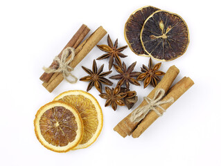 Cinnamon sticks, dry slices of lemon and orange, star anise on a white background. Spices for making mulled wine. Christmas decoration - orange, cinnamon and anise top view.