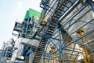 Fototapeta premium Modern factory with many pipes and tanks with stainless steel construction. This factory can produce various kinds of processed products such as oil. 