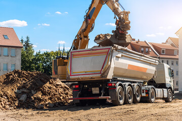 Heavy excavatore machine uploading waste and debris rubble into dump truck at construction site....