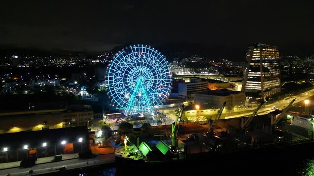 Rio de Janeiro, Brazil - August 3, 2022: Aerial view of Yup Star (Rio Star) ferris wheel at night is illuminated with colorful RGB led lights.