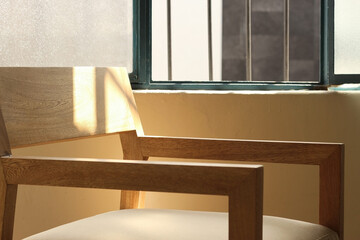 Fototapeta premium A chair modern wood frame with wooden, sunlight coming through the window illuminating the chair
