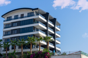 Modern apartment building with large balconies on a sunny day.