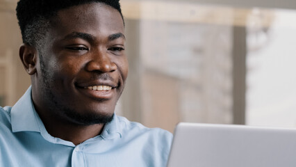 Obraz premium Thoughtful african american businessman writer dreamer genius man biracial guy holds hand on chin creates business plan come up with idea for startup uses computer typing text creates internet project