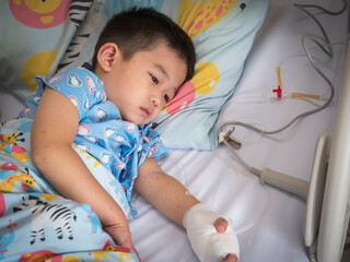 A boy with hand, foot and mouth disease is in a hospital bed.