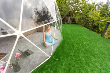 woman doing yoga in glamping dome tent - obrazy, fototapety, plakaty