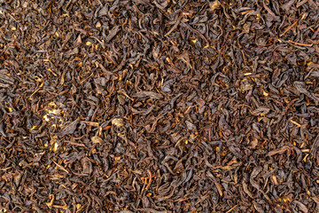 Dry black tea leaves close up. Dark background. Food and drink cooking. Texture