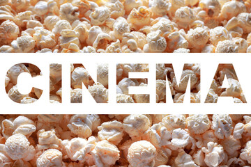 Popcorn texture background with inscription CINEMA. Word CINEMA on white background. Cinema poster concept.