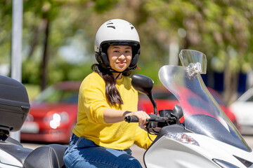 Young asian woman driving a motorbike