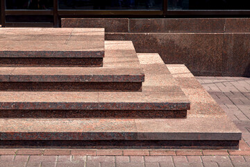 corner granite staircase with stone steps rise to the entrance building facade architecture close-up, nobody.