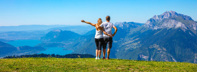 couple hiker enjoying Annecy lake view and alps mountain