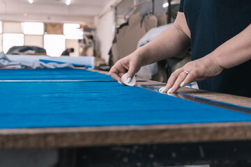 The cutter marks the fabric for cutting in the sewing workshop