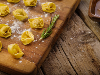 Appetizing homemade dumplings on a cutting board on a wooden background. High angle view. Recipes...