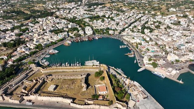 Aerial drone view of sea, harbor, boats and city architecture. Majestic view of resort town of Kos in Greece. Amazing panoramic sunrise view from 4k drone of Kos ancient castle